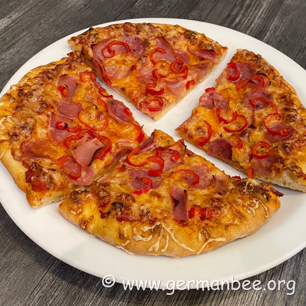 Aufgeschnittene Pizza mit lockerem Rand und knusprig gebackenem Boden