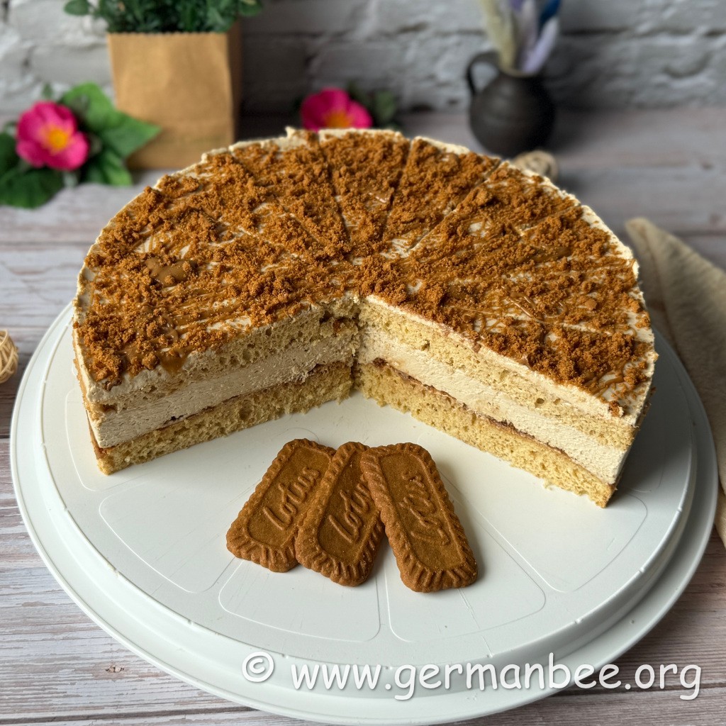 Angeschnittene milchfreie Lotustorte mit Biscoff-Biskuit, Cremefüllung und Keksbröseln